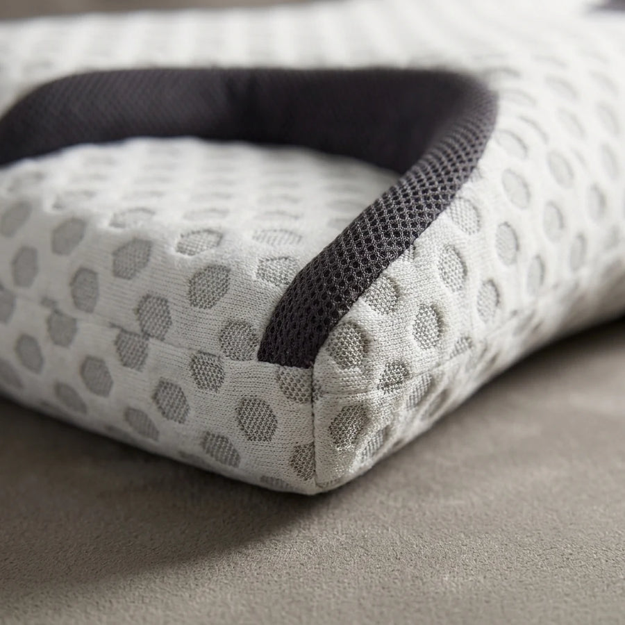 Macro view of the pillow's cutout edge where cooling fabric meets contoured foam