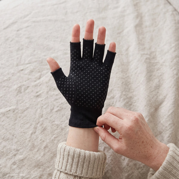 Hands pulling a compression glove on, aligning it at the wrist