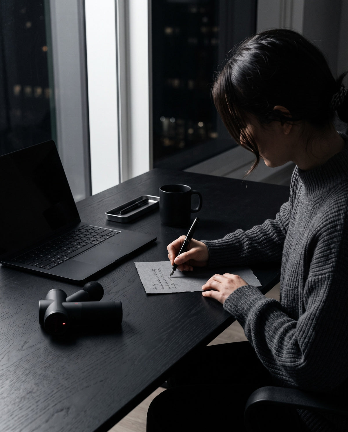 A member of the Rejuvex care team writing a note at a studio desk